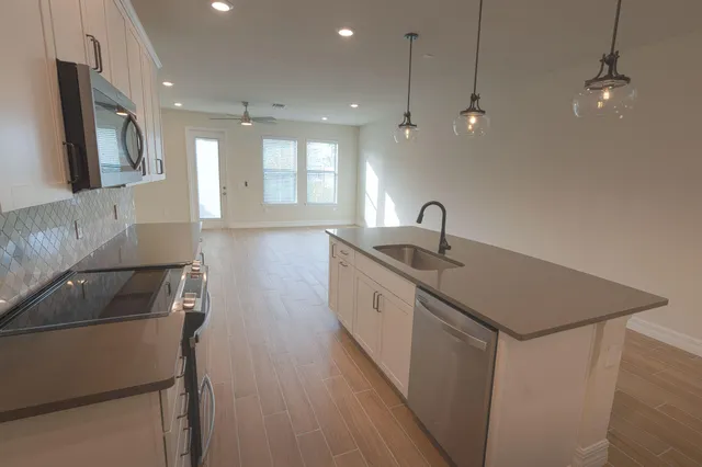 a kitchen with a sink cabinets and wooden floor