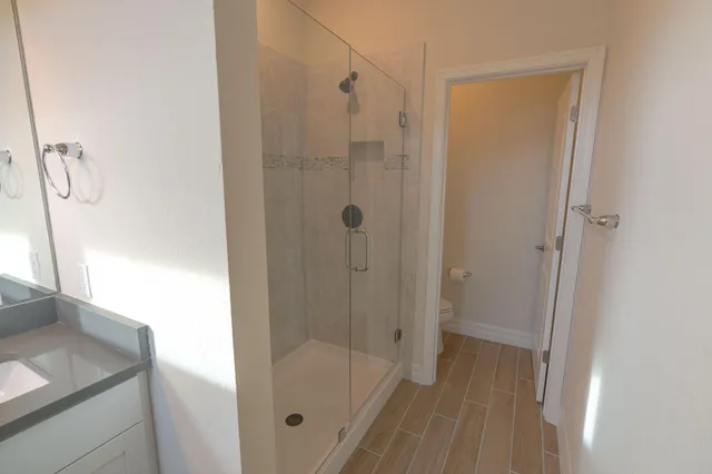 a bathroom with a sink a toilet and shower