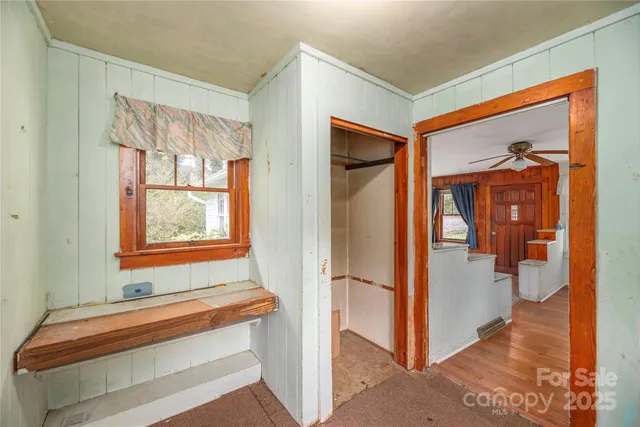 a view of front door with hallway and a mirror