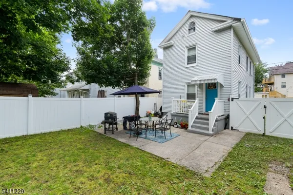 a view of a patio with table and chairs with wooden fence and plants