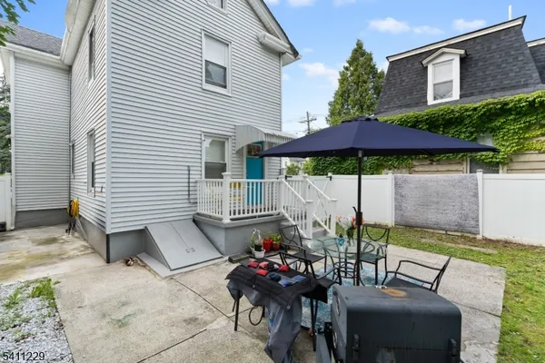 a view of a patio with table and chairs under an umbrella
