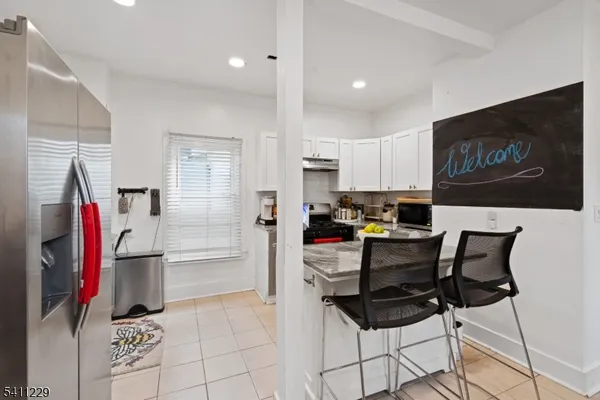 a kitchen with stainless steel appliances kitchen island granite countertop a refrigerator and a stove top oven