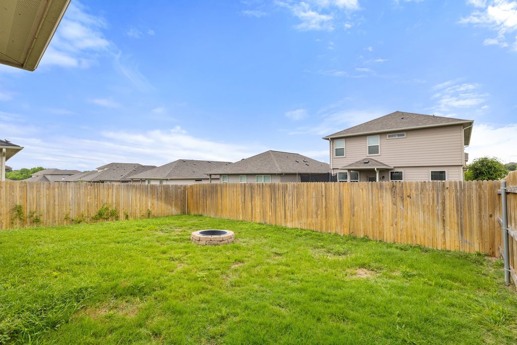102 Ashford Way Georgetown, TX 78626 - Photo 26 of 28 A well-maintained fenced yard offers a charming fire pit, ideal for outdoor gatherings.