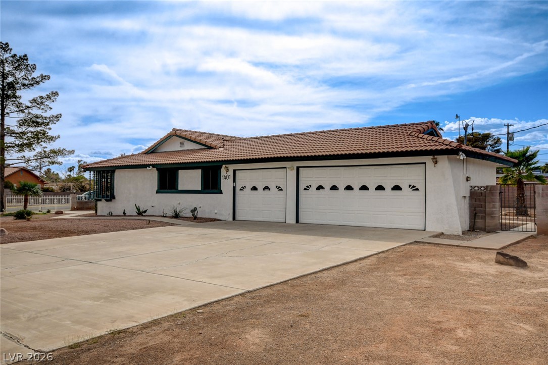 1401 Sharon Road Las Vegas, NV 89106 - Photo 11 of 73 A spacious concrete driveway leads to a multi-car garage beneath a classic tiled roofline.