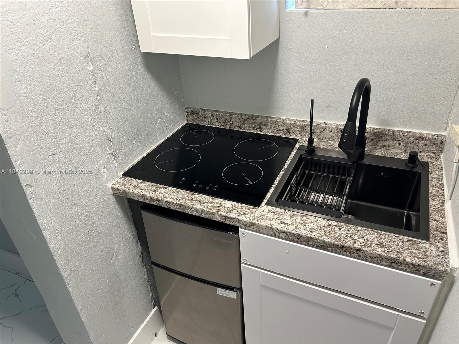 4340 Southwest 24th Street, Unit 1 West Park, FL 33023 - Photo 3 of 6 a close view of a stove sink and microwave