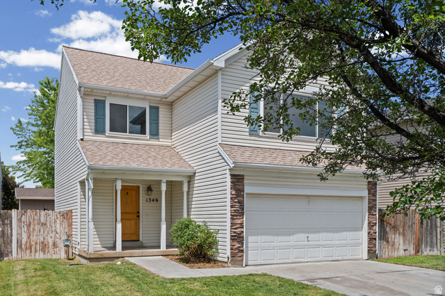 1346 Archmore Drive Springville, UT 84663 - Photo 32 of 32 Two-story residence featuring light-colored siding, a covered entryway, an attached two-car garage, and a peaked roofline