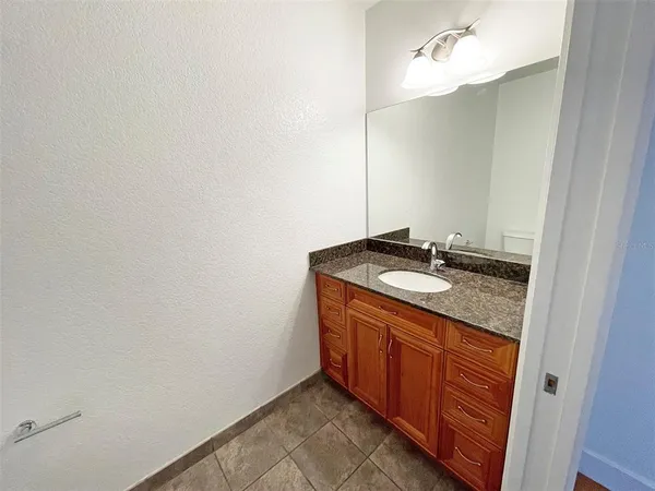 a bathroom with a granite countertop sink and a mirror