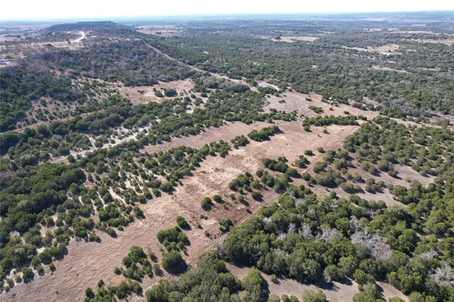 an aerial view of house with yard and mountain view in back