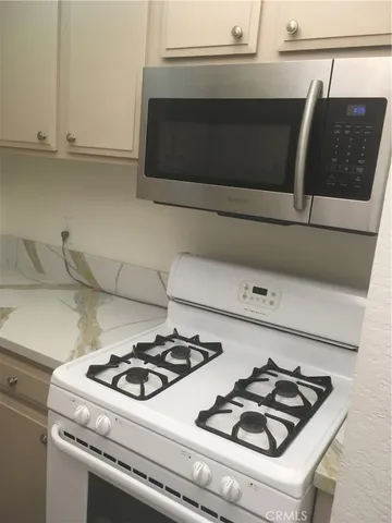 a white stove top oven sitting inside of a kitchen