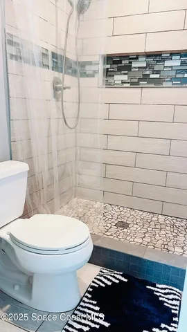 a bathroom with a toilet and a shower