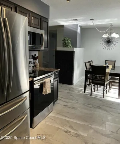 a kitchen with a refrigerator and a stove top oven