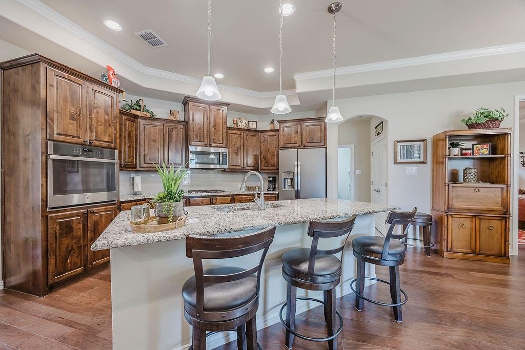2123 Ladera Way, Unit 2123 Mansfield, TX 76063 - Photo 12 of 34 a dining room with stainless steel appliances kitchen island granite countertop a dining table chairs and view living room