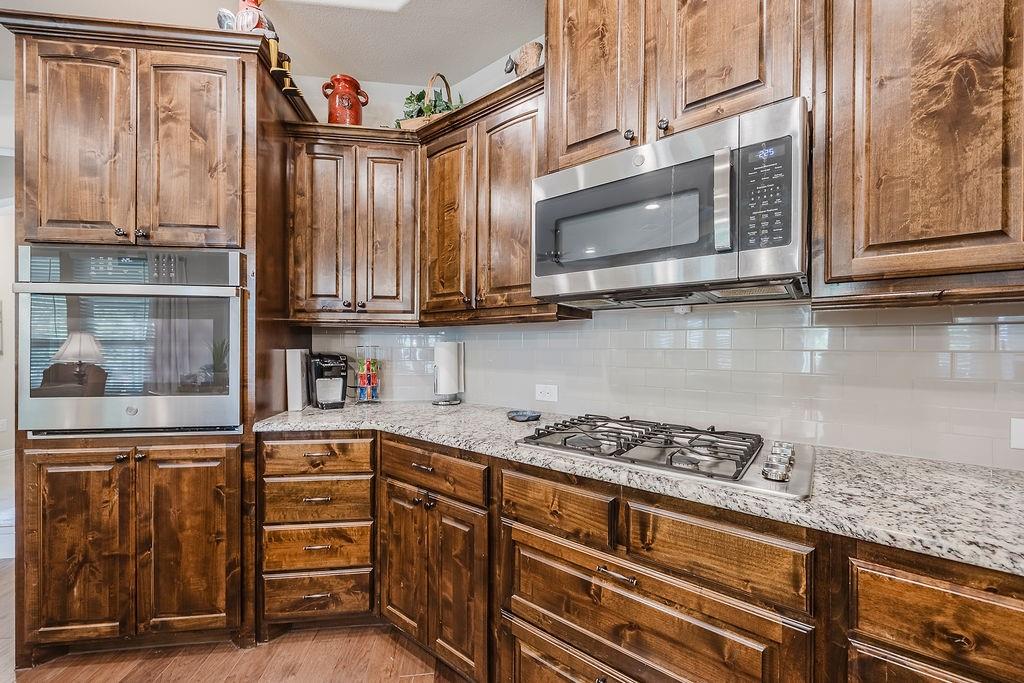 2123 Ladera Way, Unit 2123 Mansfield, TX 76063 - Photo 15 of 34 a kitchen with stainless steel appliances granite countertop a stove and cabinets