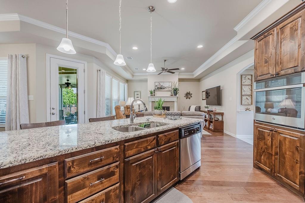 2123 Ladera Way, Unit 2123 Mansfield, TX 76063 - Photo 16 of 34 a kitchen with stainless steel appliances granite countertop a sink a stove and a wooden floors