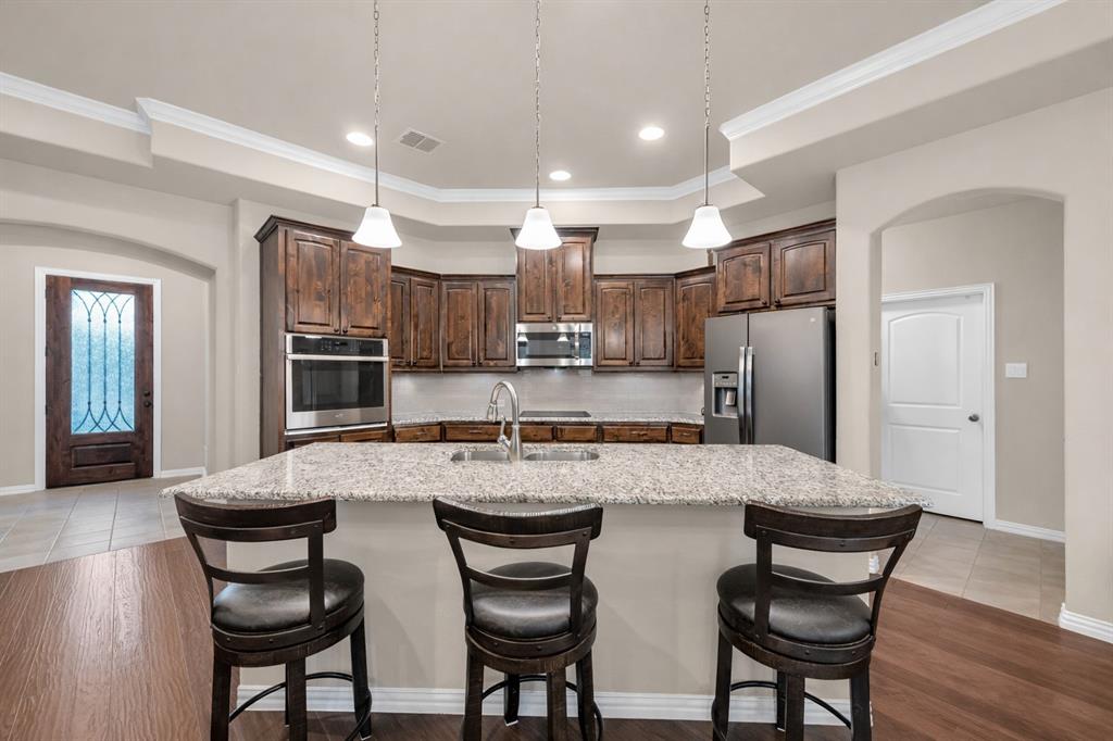 2123 Ladera Way, Unit 2123 Mansfield, TX 76063 - Photo 2 of 34 a kitchen with refrigerator a sink and chairs