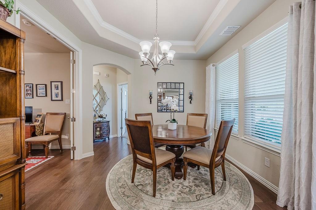 2123 Ladera Way, Unit 2123 Mansfield, TX 76063 - Photo 4 of 34 a view of a dining room with furniture a chandelier and wooden floor