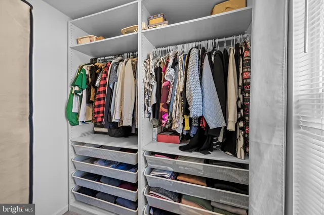 a view of walk in closet with clothes and shoes