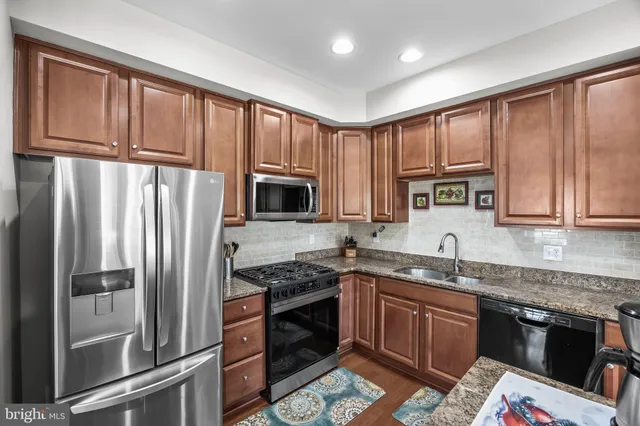 a kitchen with stainless steel appliances granite countertop a refrigerator stove microwave and sink