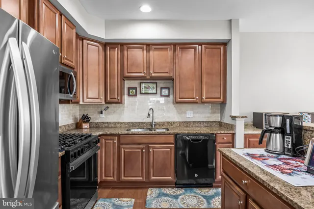 a kitchen with stainless steel appliances granite countertop a stove top oven a sink and dishwasher
