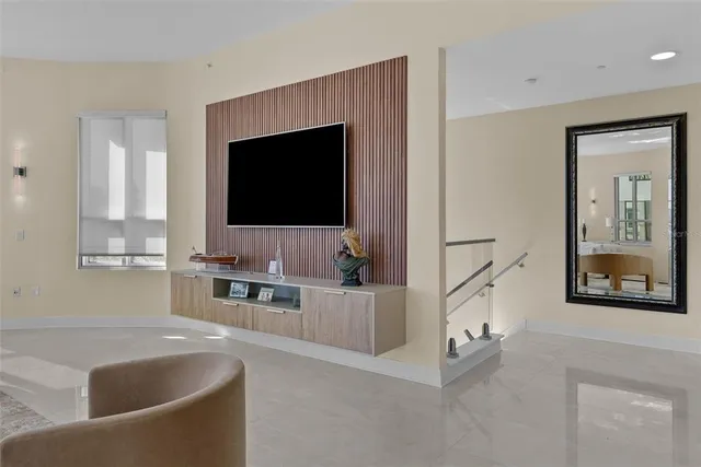 a living room with furniture a large window and a chandelier