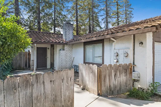 a side view of a house with wooden fence