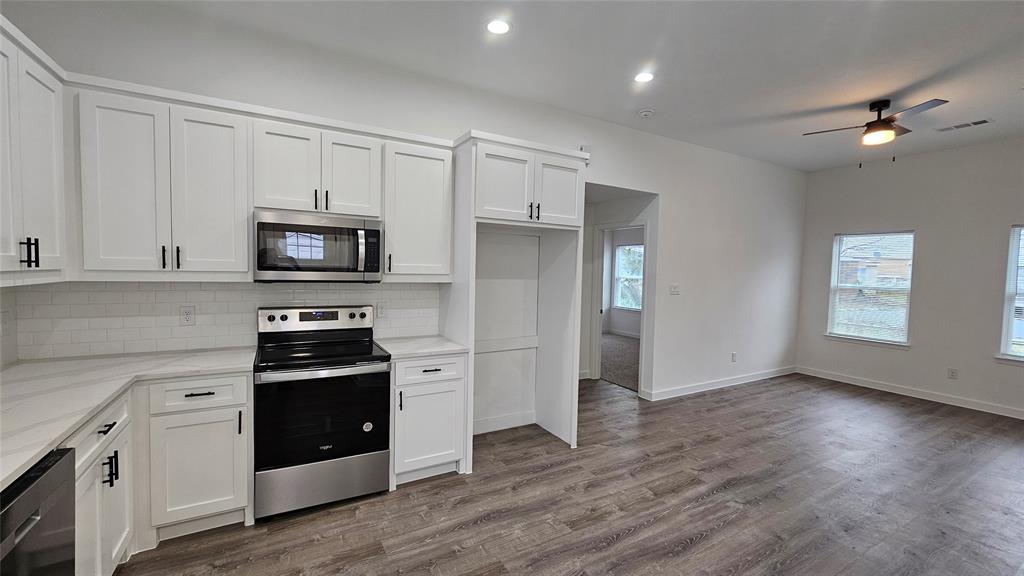 a kitchen with stainless steel appliances a stove refrigerator and microwave