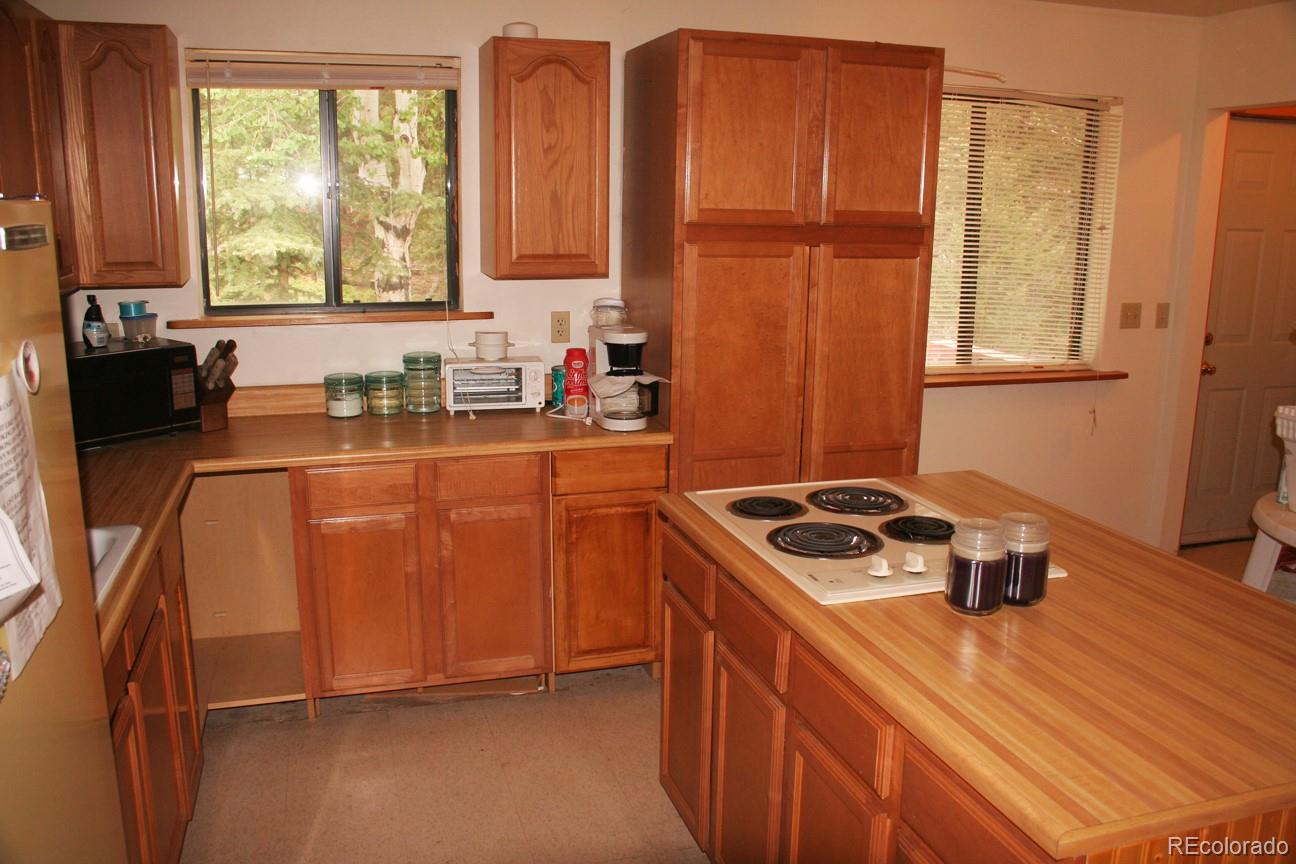 777 Singletree Road Hartsel, CO 80449 - Photo 7 of 31 a kitchen with stainless steel appliances granite countertop a sink stove and refrigerator