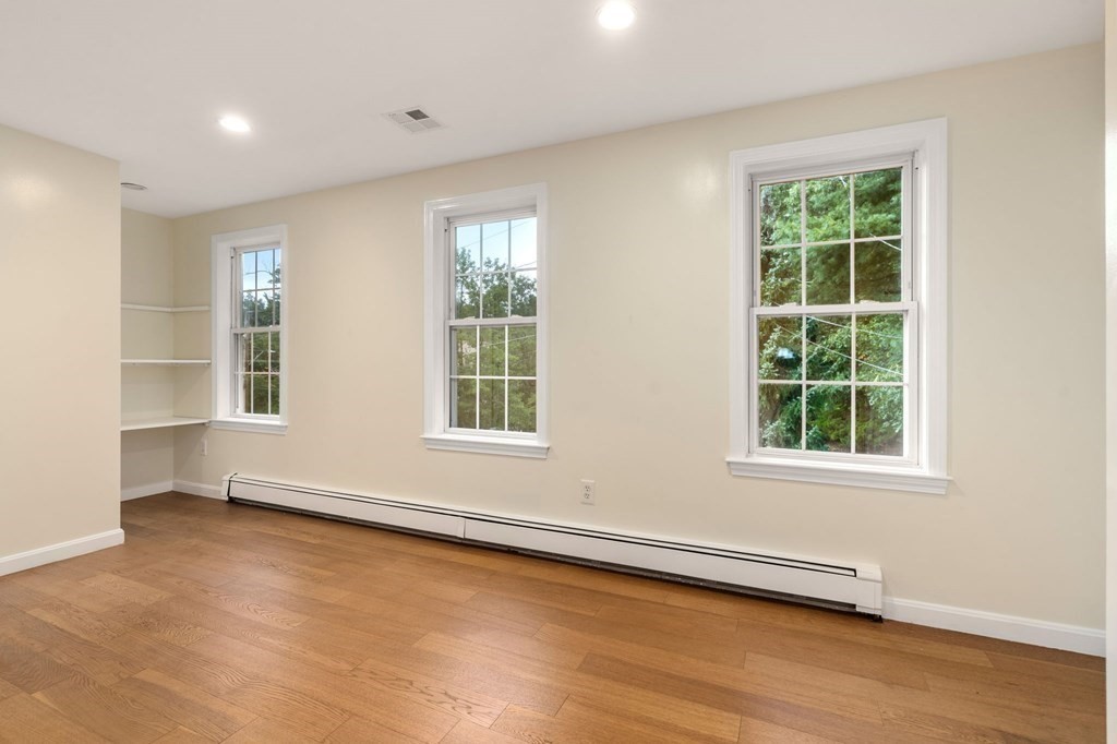 98 Allen Street Walpole, MA 02081 - Photo 25 of 37 an empty room with wooden floor and windows