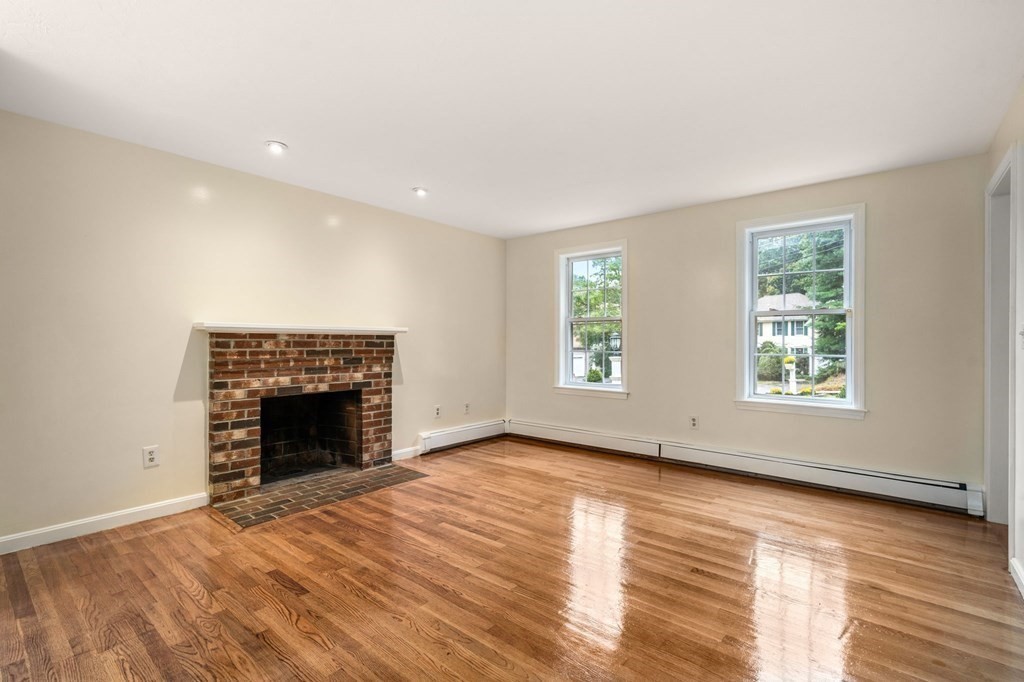 98 Allen Street Walpole, MA 02081 - Photo 5 of 37 an empty room with wooden floor fireplace and windows
