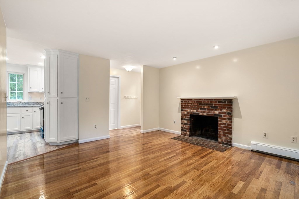 98 Allen Street Walpole, MA 02081 - Photo 6 of 37 an empty room with wooden floor and fireplace