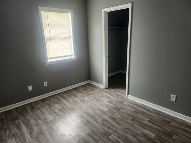 an empty room with wooden floor and closet