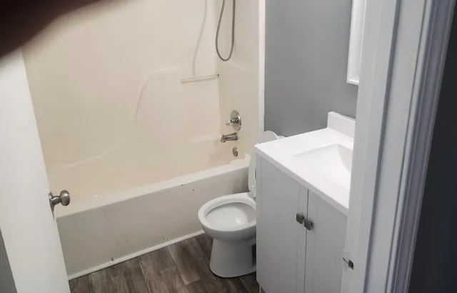 a bathroom with a sink a toilet and shower