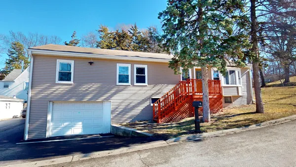 a view of a house with large trees and wooden fence