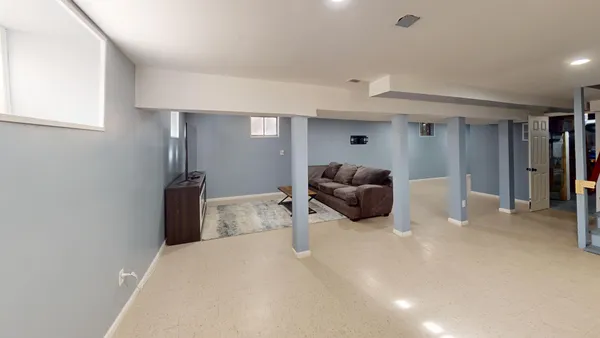 a living room with furniture a flat screen tv and a lamp