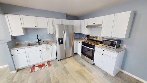 a kitchen with granite countertop white cabinets and white appliances