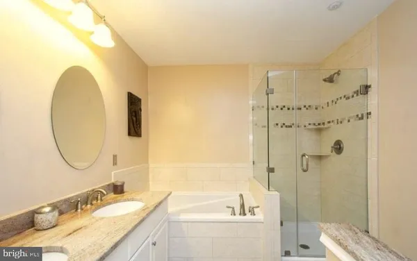 a bathroom with a granite countertop sink mirror and a bathtub