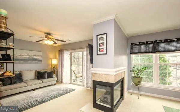 a living room with furniture a flat screen tv and a large window