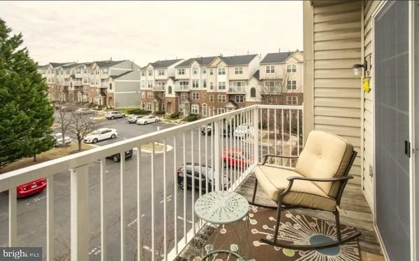 a view of a balcony with a chair and wooden floor
