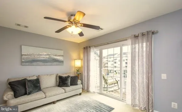 a living room with furniture and a large window with wooden floor