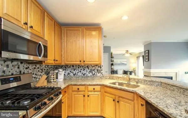 a kitchen with granite countertop a sink a stove and cabinets