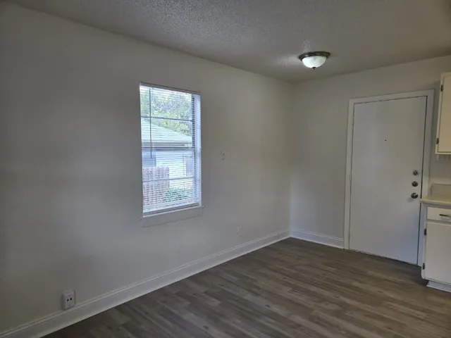 a view of a livingroom with wooden floor and window