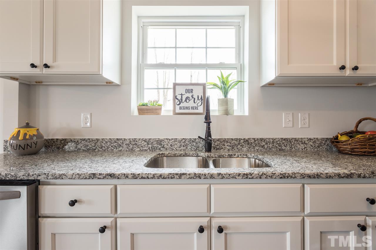 937 Wilson Road Clinton, NC 28328 - Photo 15 of 28 a kitchen with granite countertop white cabinets and a window