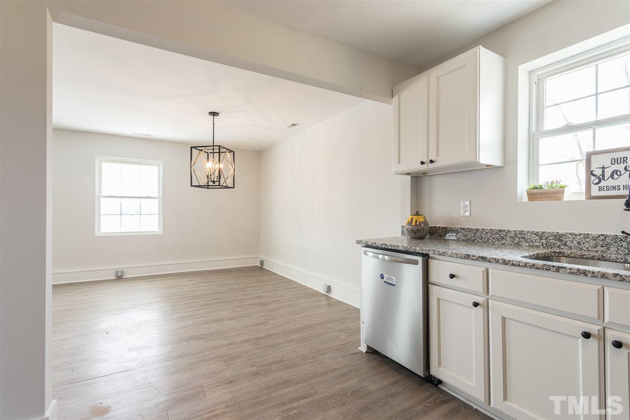 937 Wilson Road Clinton, NC 28328 - Photo 16 of 28 a kitchen with granite countertop white cabinets and a window