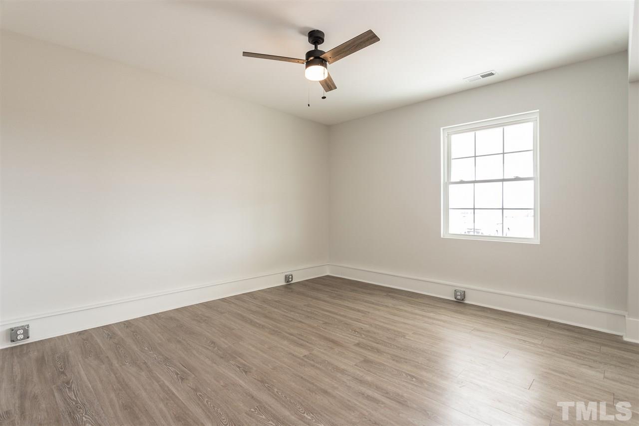 937 Wilson Road Clinton, NC 28328 - Photo 8 of 28 an empty room with wooden floor ceiling fan and windows