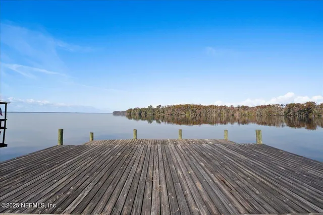 a view of a swimming pool with a table and chairs under an umbrella