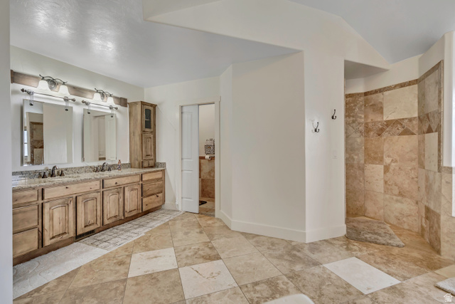 3054 West Ridgeline Road Stockton, UT 84071 - Photo 16 of 88 Full bath featuring double vanity, walk in shower, and vaulted ceiling