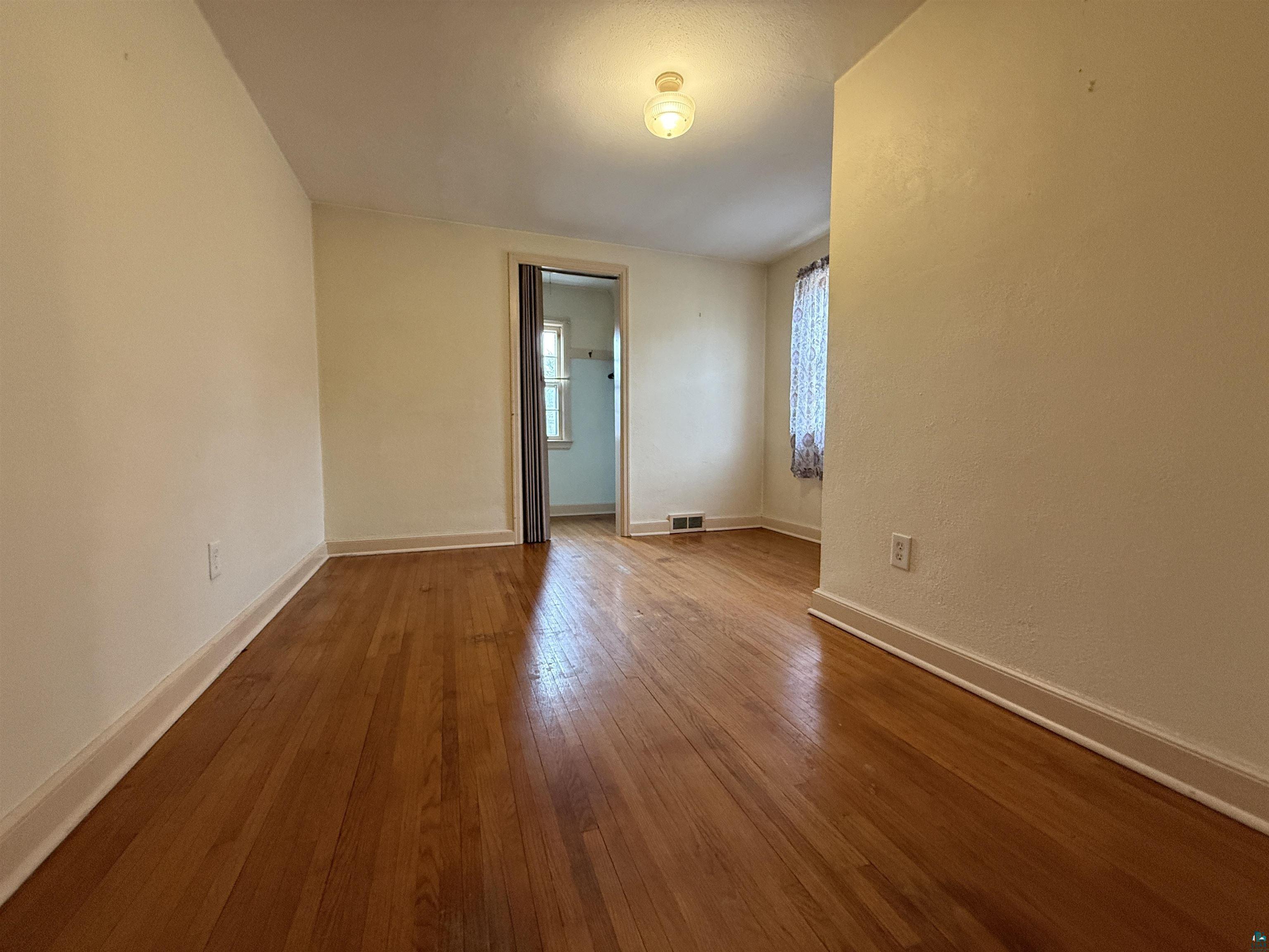 3001 3rd Avenue West Hibbing, MN 55746 - Photo 24 of 38 Unfurnished room with baseboards and hardwood / wood-style floors