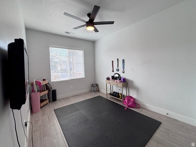 429 East Treasure Road Washington, UT 84780 - Photo 6 of 36 Exercise room featuring light wood-style flooring, a textured ceiling, and a ceiling fan
