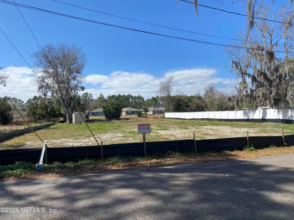 a view of a yard with wooden fence