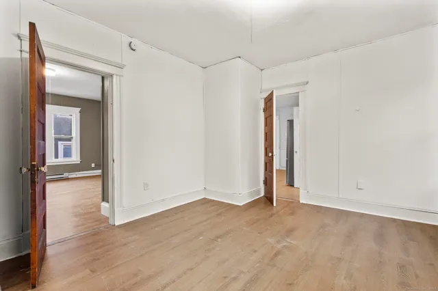 an empty room with wooden floor and closet